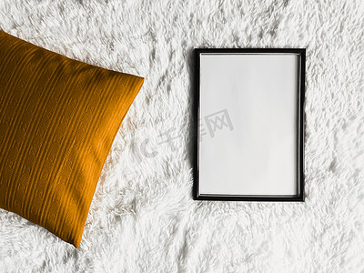 黑色薄木框架，空白复制空间作为海报照片打印模型、金色坐垫枕头和蓬松的白色毯子、平躺背景和艺术产品