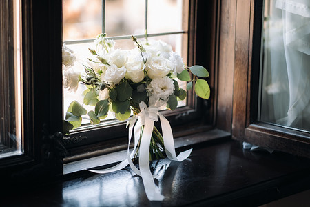 婚礼胸花摄影照片_椅子上放着牡丹和玫瑰的婚礼花束，还有胸花。婚礼上的装饰