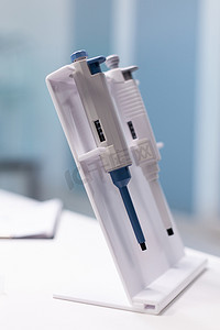 站立在桌上的医用微移液器准备好进行微生物学科学测试实验