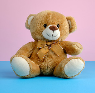 蓝色小熊摄影照片_可爱的小棕色泰迪熊，玩具坐在蓝色背景上
