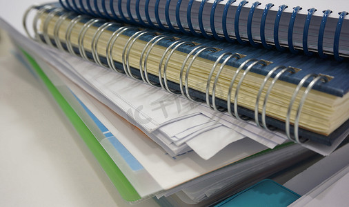 办公桌上的一叠办公文件和活页夹书