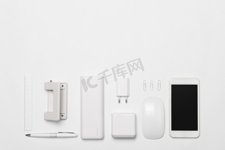 白色办公用品和智能手机在白色桌子背景与复制空间。