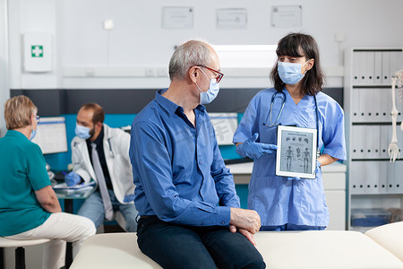护士拿着图像上带有人体骨骼的数字平板电脑