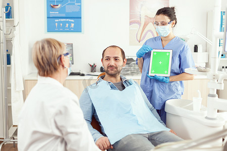 口腔科护士指着她的手在模拟绿屏色键平板电脑上