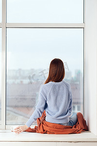 靠窗的女人梦幻般的样子在家里休息舒适