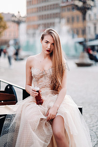 饮料瓶摄影照片_弗罗茨瓦夫老城，一位身着长发婚纱、手拿饮料瓶的新娘。