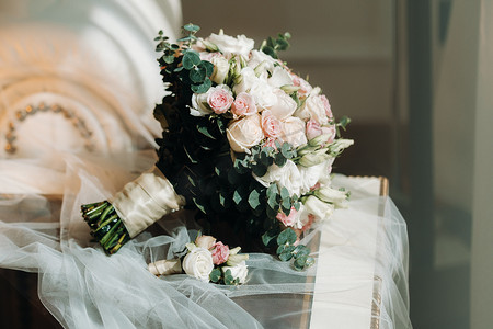 与玫瑰和胸花的婚礼花束。婚礼上的装饰