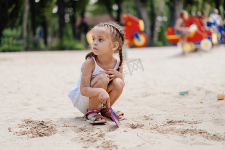 小女孩在操场上玩沙盒 挖沙铲 建筑沙图 夏日