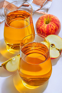 新鲜的苹果摄影照片_杯苹果汁和新鲜的苹果在白色背景。