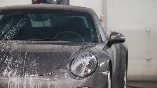 运动车摄影照片_用水管在泡沫中清洗汽车 — 运动车