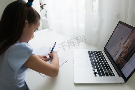 使用笔记本电脑在线学习的小女孩