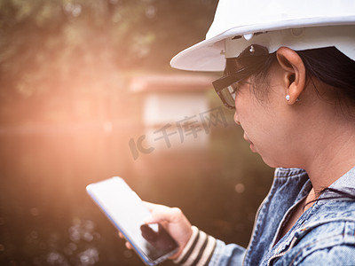 戴着安全帽的女生态学家在污水处理厂使用智能手机控制水质。