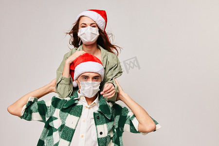 一男一女戴着防冠状病毒的医用口罩庆祝圣诞节