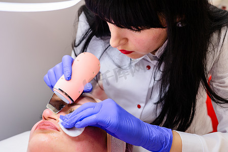 美容师使用带有微振动的超声波来滋润面部和去除角质化的旧皮肤。