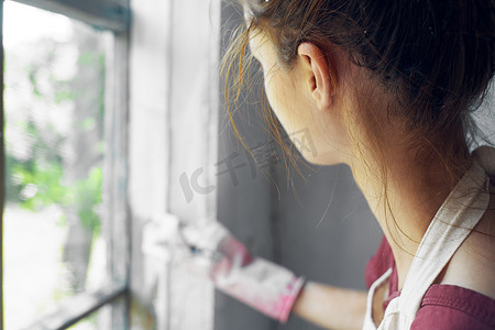 有刷子油漆窗口的妇女家庭装修内部