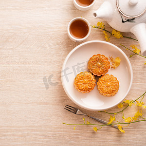 中秋节假期概念设计月饼、月饼、茶具在明亮的木桌上，有复制空间、顶视图、平躺、头顶拍摄