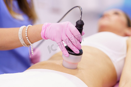 在美容诊所接受射频机抗脂肪治疗的妇女。