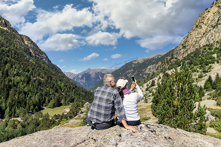 中年旅游夫妇在西班牙圣毛里奇和奥格斯托特斯的比利牛斯山用手机拍照