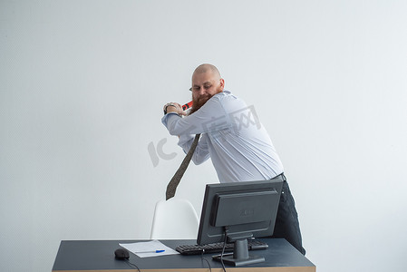 强调疯狂的商人在办公室使用斧头问题概念砸碎他的电脑。