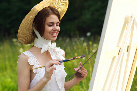 白裙摄影照片_身穿白裙的女性艺术家在自然调色板上作画
