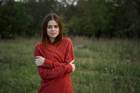 在野外自然休息中穿红色毛衣的女人