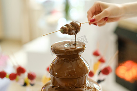 巧克力喷泉摄影照片_带有巧克力喷泉和糖果的火锅。甜蜜的主题
