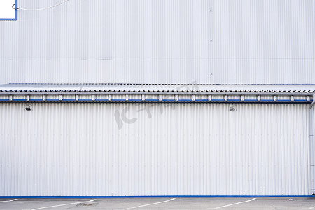 工厂门面摄影照片_用作仓库或工厂立面的白色波纹铁皮。