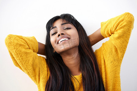 白色背景下双手枕在头后微笑的年轻印度女性的特写