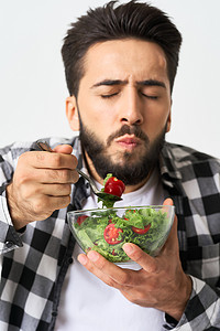 穿格子衬衫的男人摄影照片_穿格子衬衫的男人吃沙拉健康食品