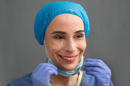 女医务人员微笑着摘下手术口罩