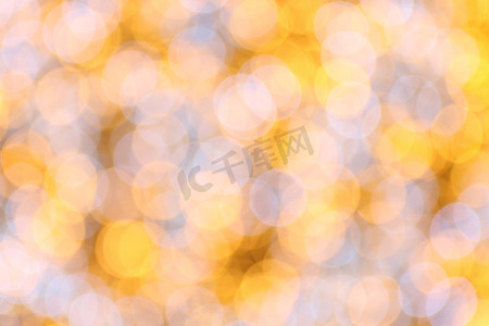 金黄色背景摄影照片_散景背景金黄色色彩缤纷的圣诞快乐，新年快乐散景照明在夜间背景上闪耀，散景闪光，金色豪华背景纹理，闪闪发光的壁纸