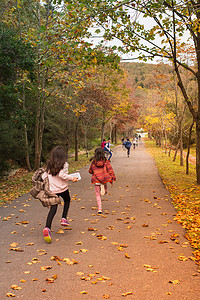 孩子们在秋天的落叶路上奔跑