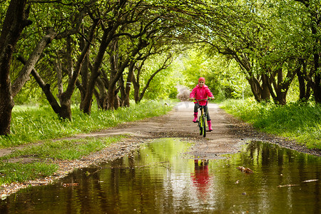小女孩在水坑里骑自行车