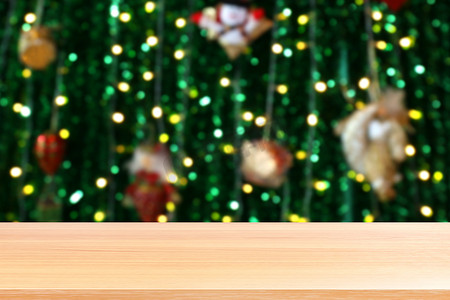 照明模糊圣诞树装饰背景上的木板，照明绿色圣诞散景上的空木桌地板，木桌板空前绿色闪光背景光多彩