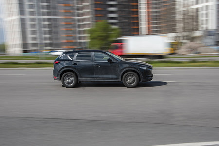 马自达汽车摄影照片_乌克兰，基辅 - 2021 年 4 月 26 日：黑色马自达 CX-5 汽车在街上行驶。