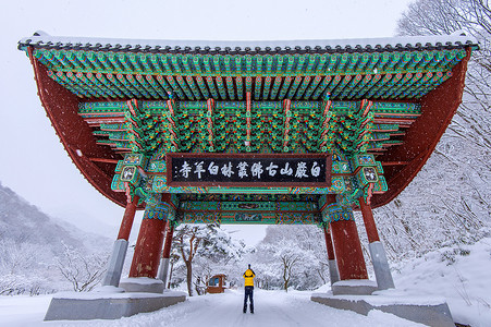 专业摄影师在韩国冬季的 Baekyangsa 寺门口和落雪、Naejangsan 山用相机拍照。冬季景观。