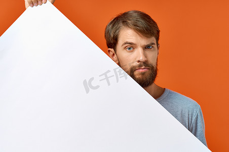 广告海报在一个橙色背景的男人手中，他用手示意 Copy Space 模型