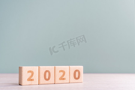 摘要 2020 设计理念 — 木桌上的几何木块立方体和低饱和度灰绿色背景，特写，复制空间。