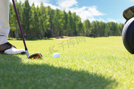 高尔夫球场在阳光明媚的日子用铁杆从球道上击球。