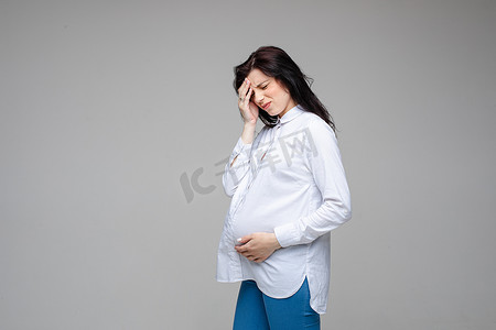 孕妇头疼摄影照片_孕妇在工作室里头疼
