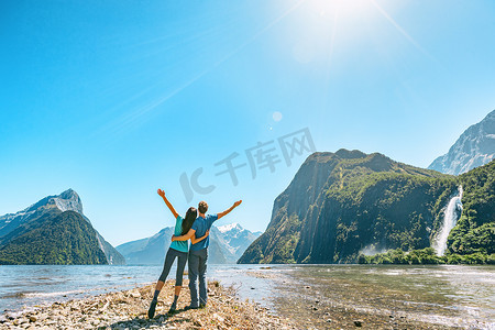 户外情侣在新西兰米尔福德峡湾的大自然中张开双臂，享受积极的户外生活方式，在新西兰米尔福德峡湾的峡湾米特峰徒步旅行