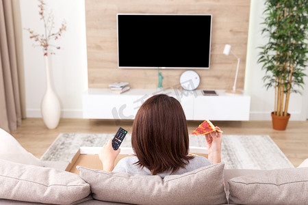 电视摄影照片_单身女人吃披萨看电视