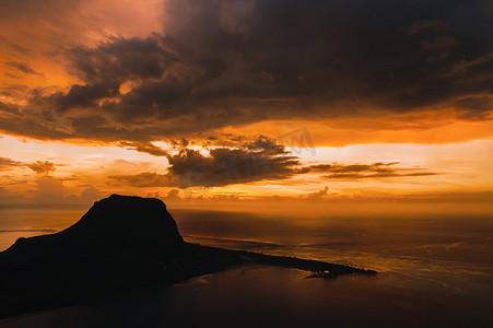 温暖的日落时间的海洋和毛里求斯的勒莫恩山的鸟瞰图。
