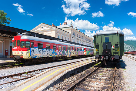 火车站背景摄影照片_新戈里察（戈里齐亚）- 2016 年 6 月，斯洛文尼亚：在阳光明媚的夏日，两列火车站在旧火车站的铁轨上，广角视角