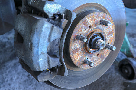 汽车轮毂维修摄影照片_汽车前盘式制动器正在更换新轮胎。
