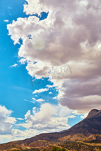 若隐若现摄影照片_在蓝天的衬托下，沙漠山上若隐若现的云彩