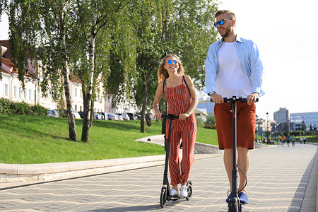 可爱的情侣在城市里驾驶电动滑板车玩得开心
