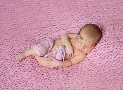 可爱的新生儿在粉红色的帽子和内裤