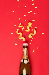 派对属性从红色背景的香槟酒瓶中飞出