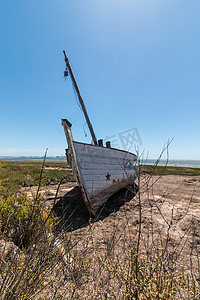 Ria Formosa 沼泽地沙丘植被上的废弃船只